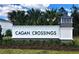 Cagan Crossings community sign with lush landscaping and mature palm trees under a blue sky at 17148 Cagan Crossings Blvd, Clermont, FL 34714