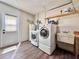 Functional laundry room with washer, dryer, sink, storage shelves, and access to the backyard at 1742 Willa Cir, Winter Park, FL 32792