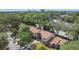 Wide aerial view of a townhouse community surrounded by lush greenery with nearby streets and parked cars at 1748 Foxhall Cir # 1748, Kissimmee, FL 34741