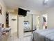 A mirrored closet reflects the bedroom, showcasing a bed, closet, and an ensuite bathroom, highlighting the layout at 1748 Foxhall Cir # 1748, Kissimmee, FL 34741