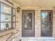 Close-up of a brick-clad townhouse facade with a dark gray door, window, and overhead lantern at 1748 Foxhall Cir # 1748, Kissimmee, FL 34741