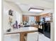 Kitchen bar area with black appliances and wood cabinets at 1748 Foxhall Cir # 1748, Kissimmee, FL 34741