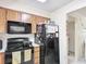 Kitchen with black appliances and wood cabinets at 1748 Foxhall Cir # 1748, Kissimmee, FL 34741