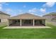 Rear exterior showcasing the screened lanai and brick-paved patio, surrounded by lush green lawn at 1835 Southern Red Oak Ct, Ocoee, FL 34761