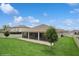Rear view featuring screened-in porch and a well-manicured green lawn at 1835 Southern Red Oak Ct, Ocoee, FL 34761