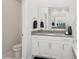 This half-bathroom features a toilet, vanity, mirror and decorative vase at 1835 Southern Red Oak Ct, Ocoee, FL 34761