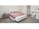 Cozy bedroom featuring a tufted headboard bed, bench, and a vanity with a mirror at 1835 Southern Red Oak Ct, Ocoee, FL 34761