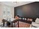 Home office featuring a black accent wall, built-in shelving, modern desk, and comfortable seating at 1835 Southern Red Oak Ct, Ocoee, FL 34761