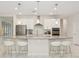 Modern kitchen featuring white cabinets, stainless steel appliances, a gray backsplash, and a spacious island with seating at 1835 Southern Red Oak Ct, Ocoee, FL 34761