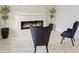 Stylish living room showcasing a fireplace, stone accent wall, modern decor, and sleek chairs at 1835 Southern Red Oak Ct, Ocoee, FL 34761