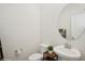 Modern powder room features a pedestal sink, round mirror and neutral decor to make it inviting at 1835 Southern Red Oak Ct, Ocoee, FL 34761