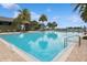 Large community swimming pool with lounge chairs, umbrellas, and palm trees at 1835 Southern Red Oak Ct, Ocoee, FL 34761