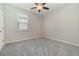 Neutral bedroom featuring gray carpeting, ceiling fan, and a white door at 1997 Standing Rock Cir, Oakland, FL 34787