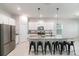 Bright kitchen features white cabinets, stainless steel appliances, granite countertops, and a large island with seating at 1997 Standing Rock Cir, Oakland, FL 34787