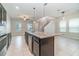 Open concept kitchen with an island and bar seating, flowing seamlessly into the dining and living areas at 1997 Standing Rock Cir, Oakland, FL 34787