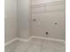 A clean and simple laundry room with tile flooring and a wire rack shelf at 1997 Standing Rock Cir, Oakland, FL 34787