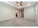 Spacious carpeted main bedroom with recessed ceiling, ceiling fan, and en-suite bathroom at 1997 Standing Rock Cir, Oakland, FL 34787