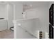 Hallway with white walls, stairwell with metal railings, laundry room with appliances and pet bed at 2054 Education St, St Cloud, FL 34771