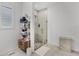 Modern bathroom showcasing a glass-enclosed shower, tile floors, and a shelving unit for storage at 2223 Blue Salvia St, Clermont, FL 34711
