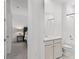 Bathroom with a shower/tub combo, sink with cabinet, and a view into the bedroom at 2223 Blue Salvia St, Clermont, FL 34711