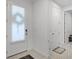 Hallway with white walls, tiled floors and a white front door with window at 2223 Blue Salvia St, Clermont, FL 34711