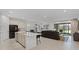 Open concept kitchen with stainless appliances, island with seating, and views of the living area and backyard at 2223 Blue Salvia St, Clermont, FL 34711