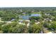 Aerial view of homes situated near a tranquil lake surrounded by lush trees in a peaceful neighborhood at 244 Angeles Rd, Debary, FL 32713