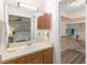 Bright bathroom with wood cabinets, walk-in closet, and views into the bedroom at 244 Angeles Rd, Debary, FL 32713