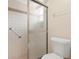 Compact bathroom featuring a sliding glass shower and toilet with grab bar at 244 Angeles Rd, Debary, FL 32713