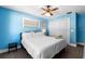 A bright blue bedroom with a ceiling fan and natural light from the window at 244 Angeles Rd, Debary, FL 32713