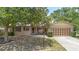 Inviting single-story brick home with brown shutters, a well-manicured lawn, and a large shade tree at 244 Angeles Rd, Debary, FL 32713
