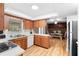 Well-lit kitchen area with wood cabinets, laminate flooring, and an open dining space at 244 Angeles Rd, Debary, FL 32713