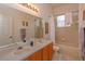 Bathroom with wood cabinets, double sink, and a shower/tub combo at 244 Ballyshannon Dr, Davenport, FL 33897