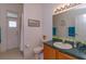 Bathroom with wood cabinets, a large mirror and a shower with glass doors at 244 Ballyshannon Dr, Davenport, FL 33897