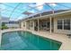 Inviting screened-in pool with an outdoor kitchen and dining area at 244 Ballyshannon Dr, Davenport, FL 33897