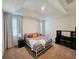 Well-lit bedroom with a large bed, carpeted floors, and stylish furniture at 2456 Varenna Loop, Kissimmee, FL 34741