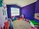 Brightly painted bedroom with carpet, large window, and filled with various toys at 2456 Varenna Loop, Kissimmee, FL 34741