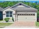 Charming home features a two-car garage, brick driveway, manicured landscaping, and a well-maintained lawn at 2456 Varenna Loop, Kissimmee, FL 34741