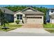 Charming home features a two-car garage, brick driveway, manicured landscaping, and a well-maintained lawn at 2456 Varenna Loop, Kissimmee, FL 34741