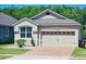 Charming home features a two-car garage, brick driveway, manicured landscaping, and a well-maintained lawn at 2456 Varenna Loop, Kissimmee, FL 34741