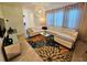 Bright living room with an L-shaped white sofa, decorative chandelier, and tiled floor at 2456 Varenna Loop, Kissimmee, FL 34741