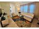 Bright living room with an L-shaped white sofa, decorative chandelier, and tiled floor at 2456 Varenna Loop, Kissimmee, FL 34741