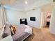 Comfortable main bedroom featuring carpet, TV, desk and a glimpse into a large walk in closet at 2456 Varenna Loop, Kissimmee, FL 34741