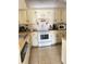 Functional kitchen with white cabinets, tiled flooring, and modern appliances at 2514 Citrus Club Ln # 308, Orlando, FL 32839