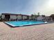 Community pool with brick paver deck, lounge chairs, and nearby apartment building under a bright sky at 2514 Citrus Club Ln # 308, Orlando, FL 32839