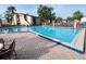 Bright community pool surrounded by brick pavers and a security fence with the apartment building behind at 2514 Citrus Club Ln # 308, Orlando, FL 32839