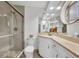 Bright bathroom featuring a glass enclosed shower, a neutral vanity with ample storage and decorative mirror at 2524 Sweetwater Trl, Winter Park, FL 32789