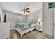 A bright bedroom features wood flooring, a ceiling fan, and a large window for natural light at 2524 Sweetwater Trl, Winter Park, FL 32789