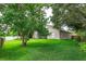 Backyard featuring green lawn, mature trees, and screened in lanai at 300 Churchill Dr, Longwood, FL 32779
