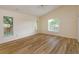 Bright bedroom featuring neutral paint, wood floors, large windows, and high ceilings at 300 Churchill Dr, Longwood, FL 32779
